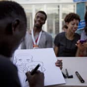 Artist creating a sketch of event goers