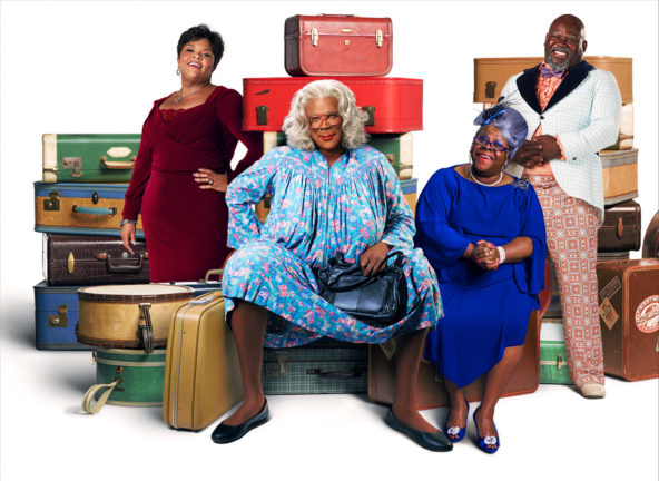 Madea and friends sitting among suitcases