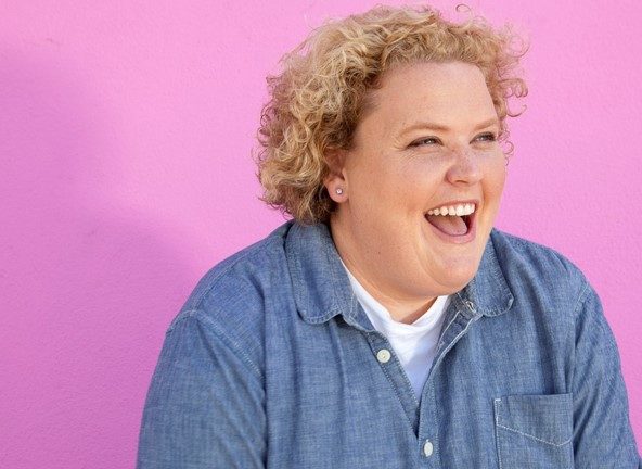 Fortune Feimster laughing with pink background