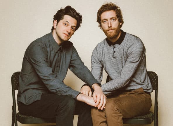 Grainy photo of Middleditch and Schwartz sitting with hands on each other's knees