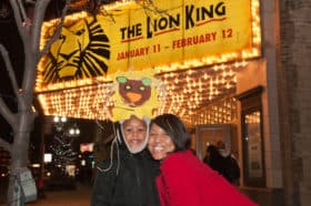 Woman and child smiling in front of Lion King marquee at the Orpheum Theatre