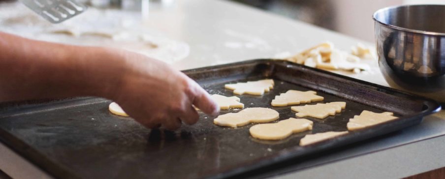 Person putting sugar cookies on a baking sheet. Photo by Kari Shea on Unsplash