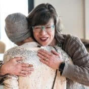 Joan Vorderbruggen and a guest at 5 to 10 at Hennepin embrace at a community meal