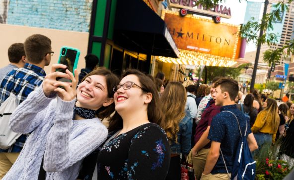 Students pose in front of the Orpheum Theatre marquee before Hamilton