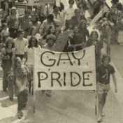 Vintage photo of the Minneapolis Gay Pride Parade. A group of people hold a large banner with the words 