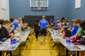 Students at the YMCA stuff backpacks for youth in need