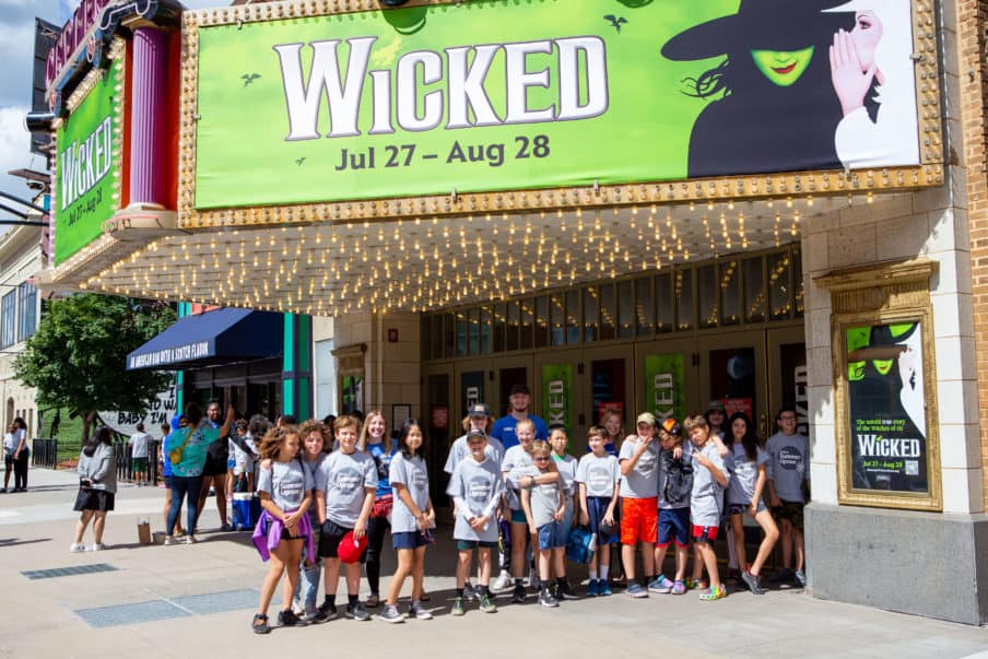 Local students from the YMCA standing under the Wicked marquee outside of the Orpheum Theatre in Minneapolis