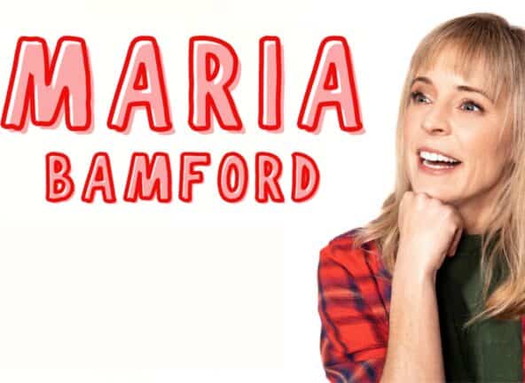 Maria Bamford smiles with a fist on her chin